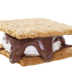 Smores: graham wafer crackers with melted marshmallows and chocolate. This camping favorite is prepared over an open flame and makes a great treat.