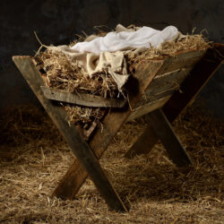 Manger with hay and swaddling clothes in old stable